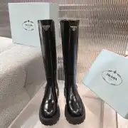 Prada's Sleek Black Knee-High Boots Featuring Glossy Texture and Iconic Logo #A54584