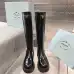 Prada's Sleek Black Knee-High Boots Featuring Glossy Texture and Iconic Logo #A54584
